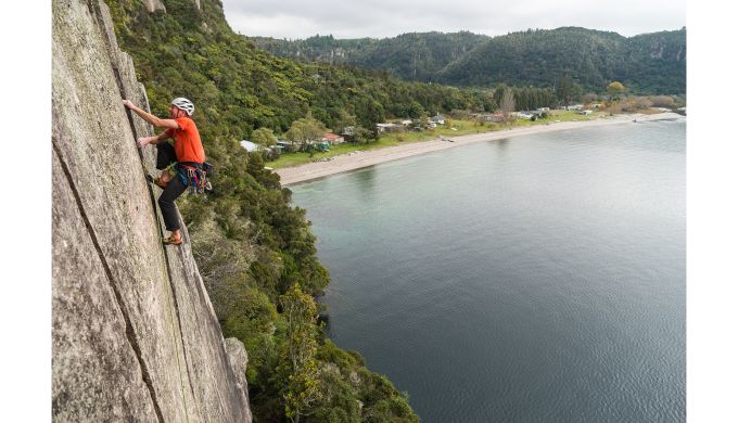 Climber on crack climb above lake
