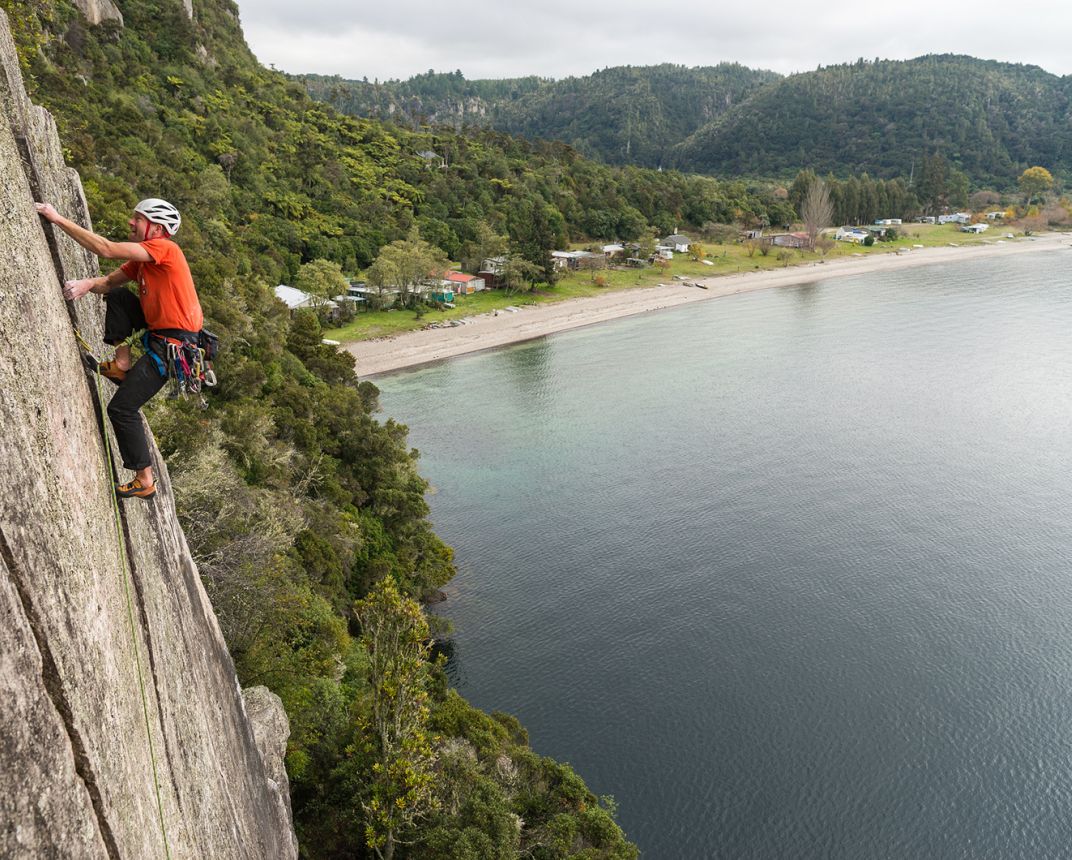 Climber on crack climb above lake