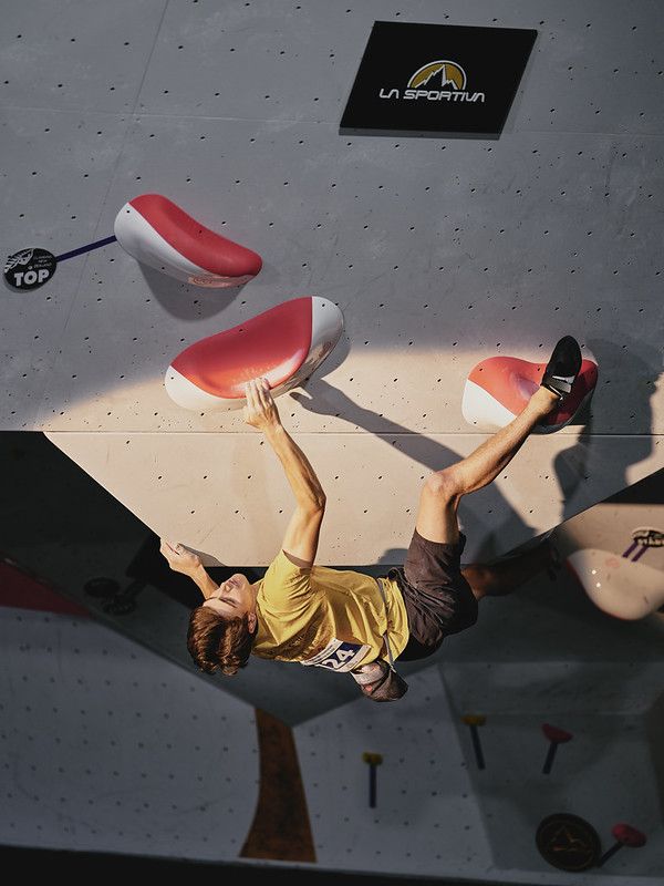 Male competitor on competition boulder problem