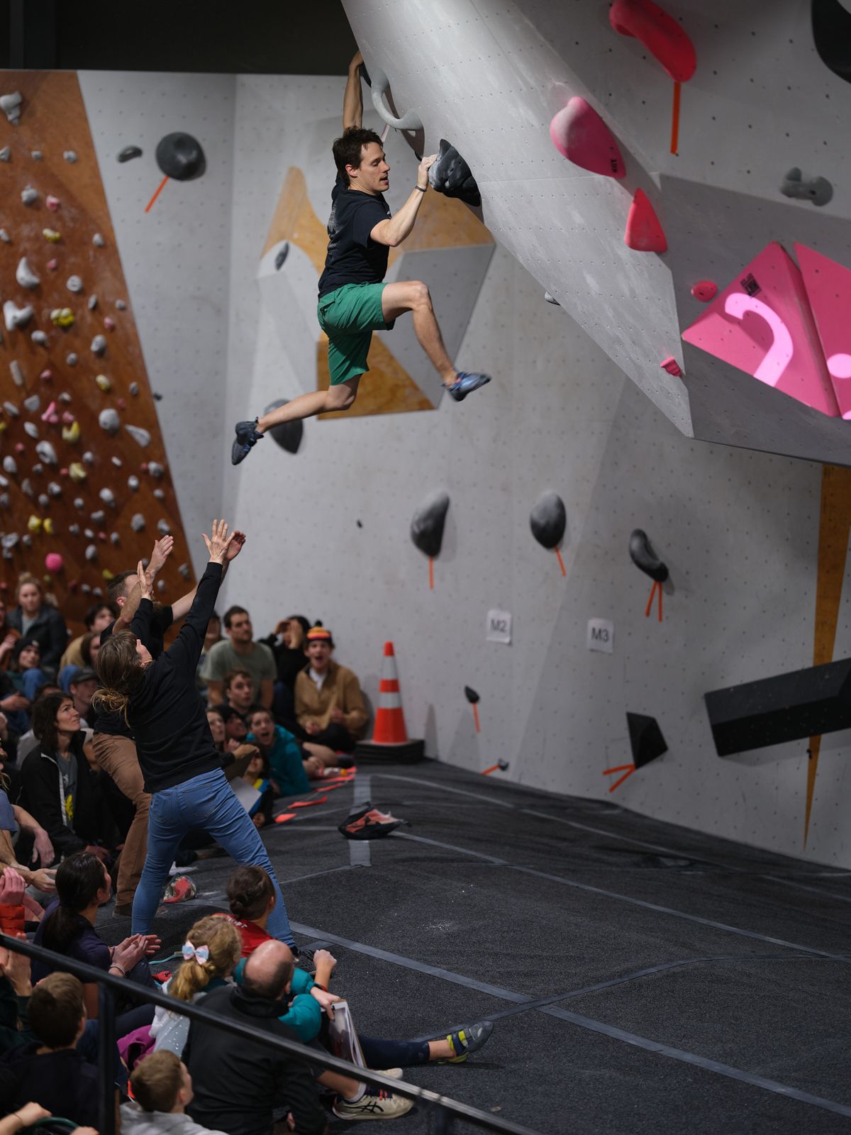Climber tops competition boulder.