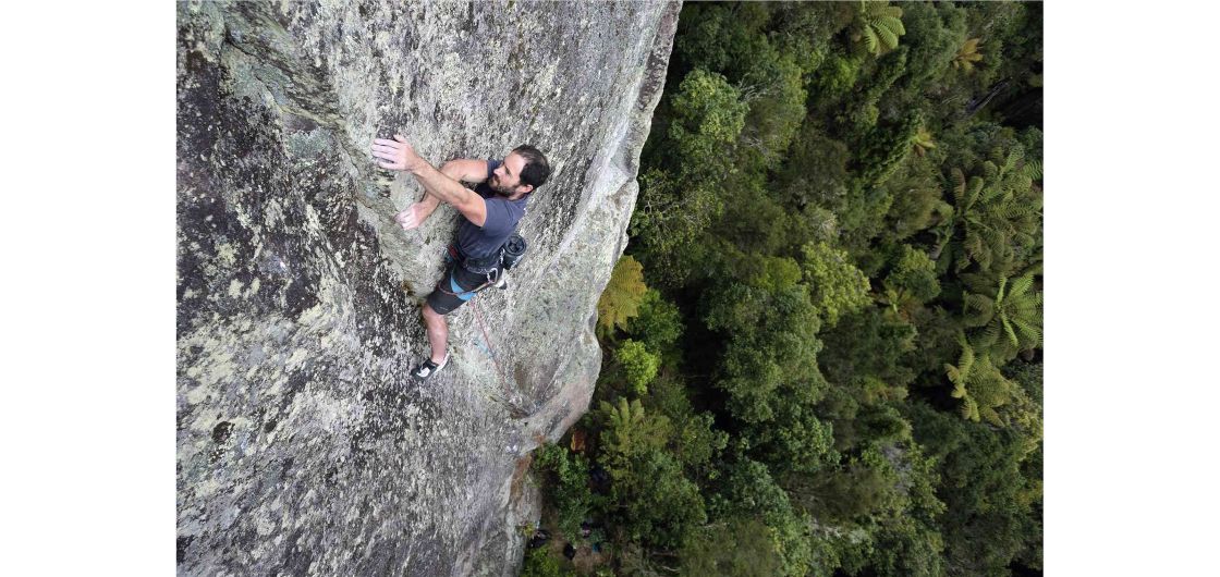 Kieran Liddicoat making the most of a re-opened Whanganui Bay, winter 2022. Photo: John Palmer Climber on lichenous ignimbrite