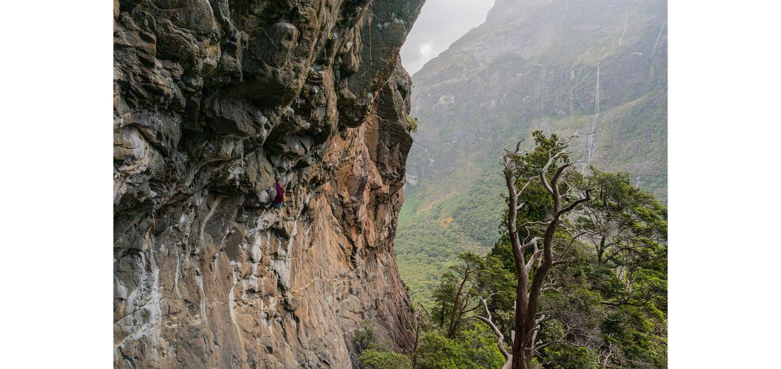 Climber on steep granite in fiords