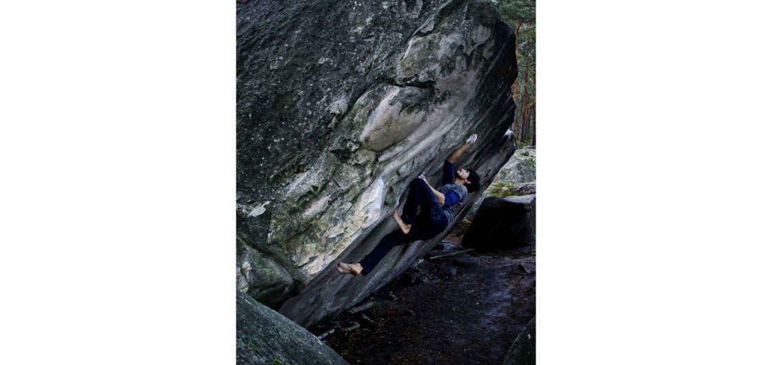 Barefoot climber on steep boulder