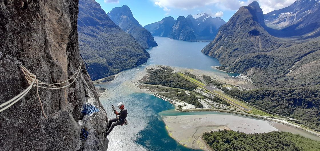 Climber on big wall above fiords.