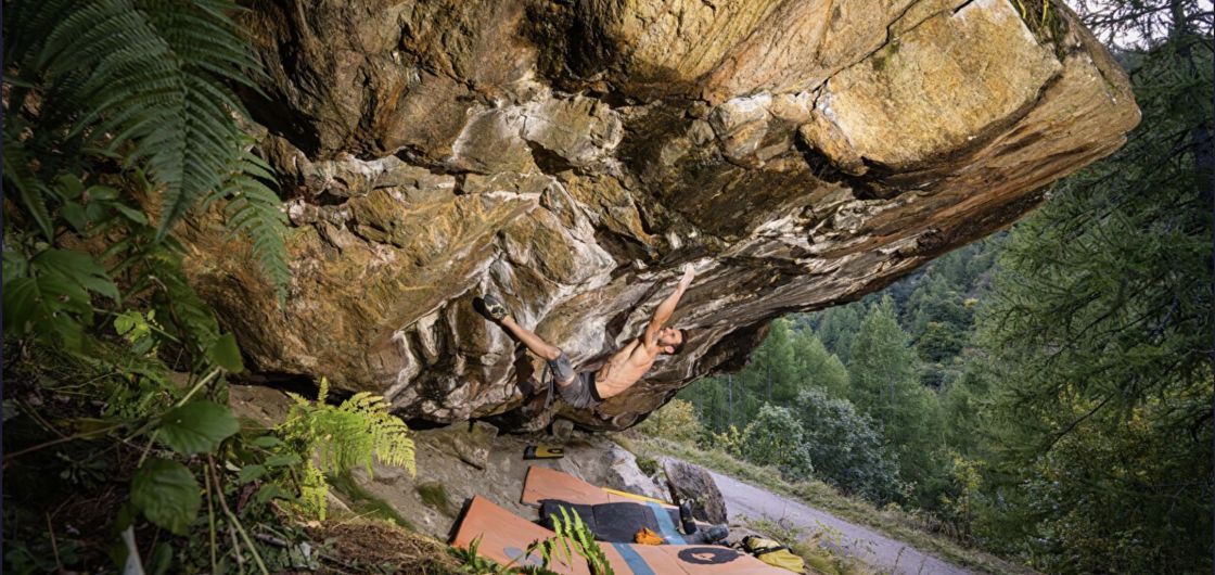 Climber on hard steep boulder problem