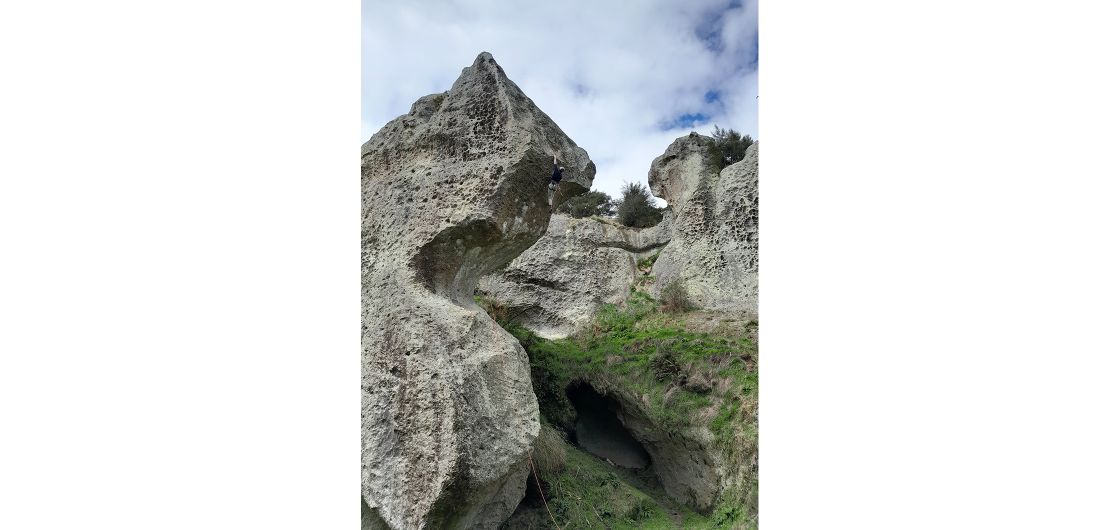 Oliver high on the route. Photo: Izzy Shanks Climber on absurdly-shaped rock formation