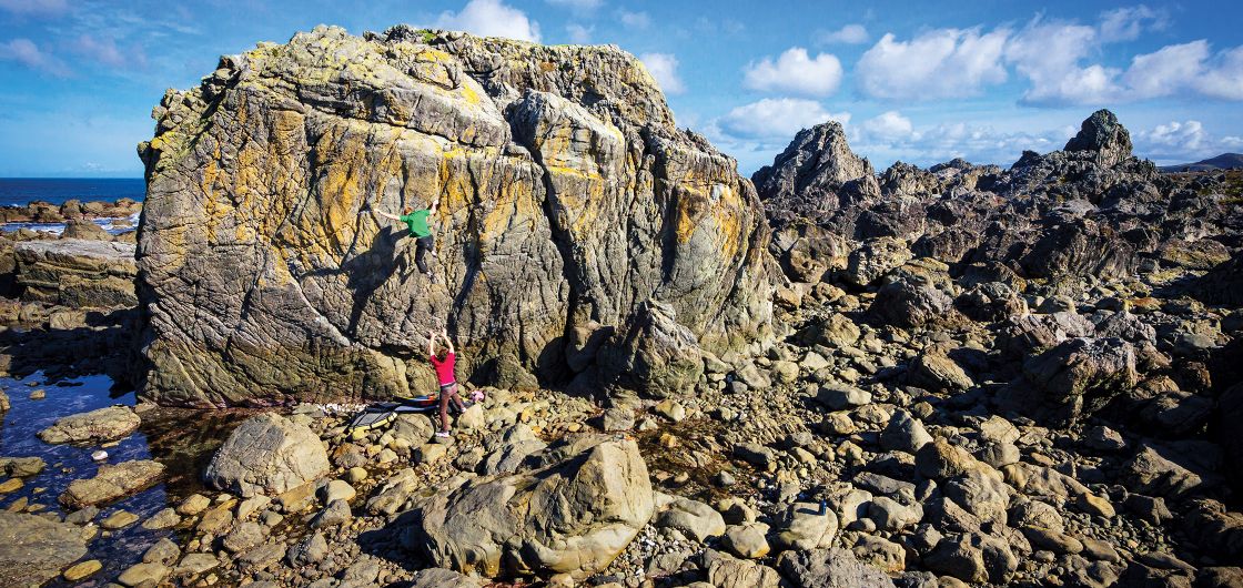 Boulderer falling from high on a seaside boulder