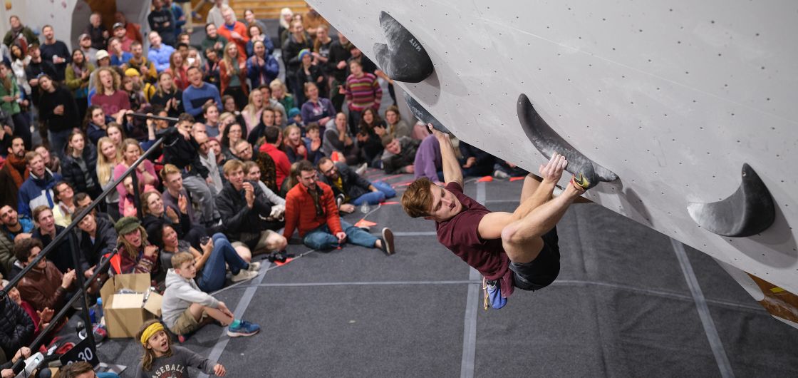 Josh Cornah climbing to victory in the Open Men's category. Photo: Tom Hoyle Competition climber on steep overhanging boulder problem.