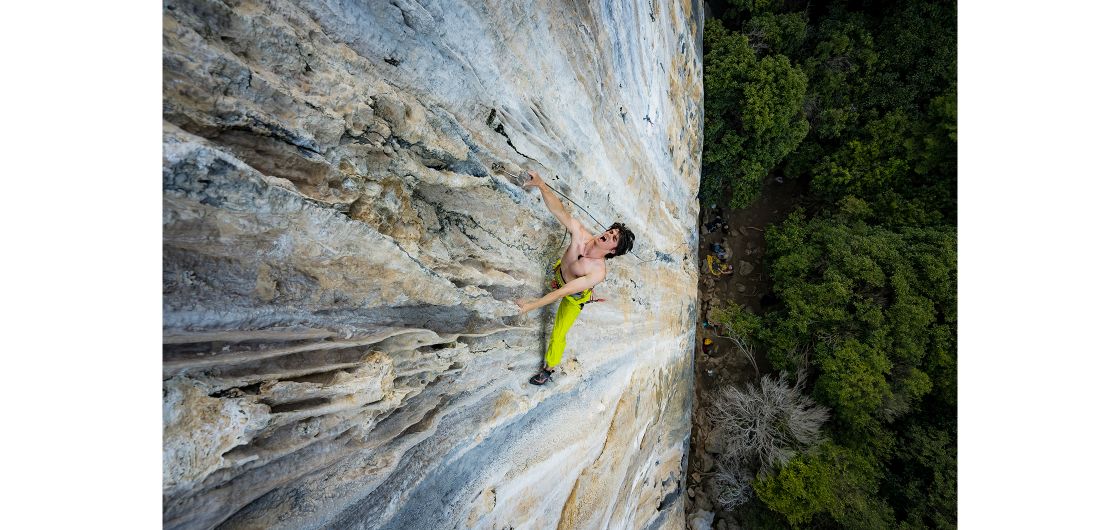 Clip it! - Alisdair Armstrong strains as he stretches for a clip on Claimjumper (27), Gold Strike, Mt Owen. By Derek Cheng Rock climber clips carabiner