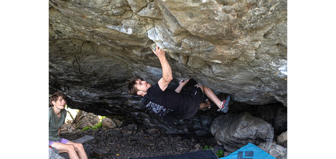 George Sanders on The Undertaker (V14). Photo by Kelly Marie Boulderer on steep underside of boulder