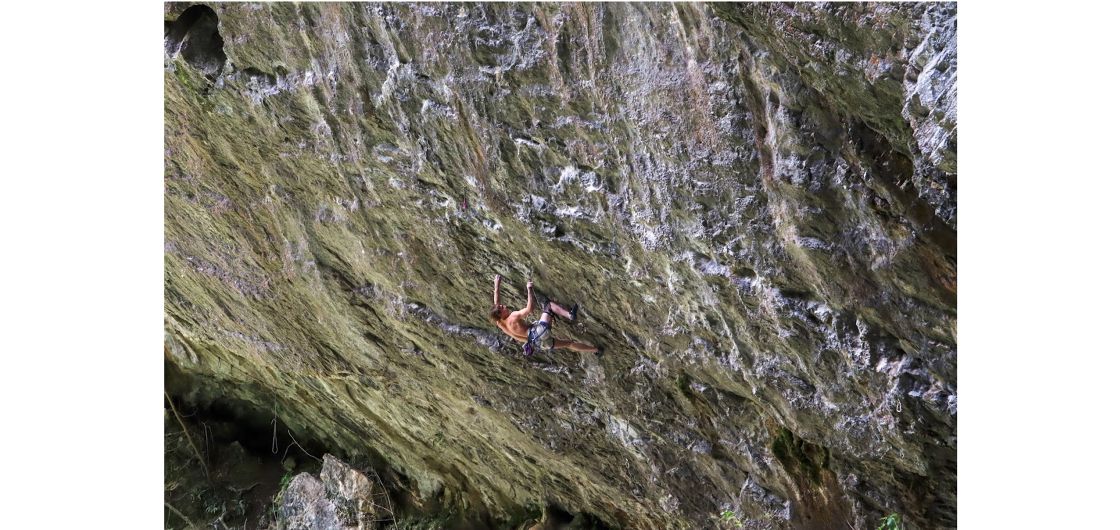 Climber on very overhanging wall and just holding on by their very fingertips