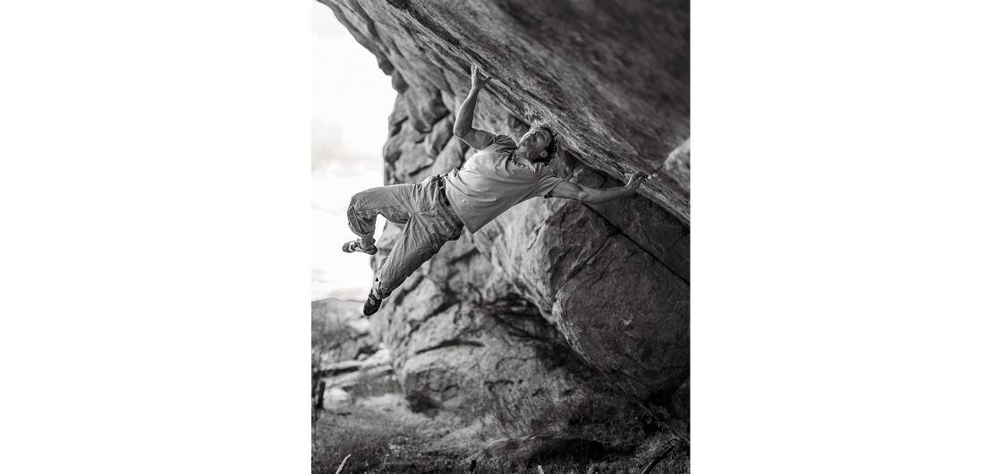 Climber on mega hard boulder with muscles in weird places
