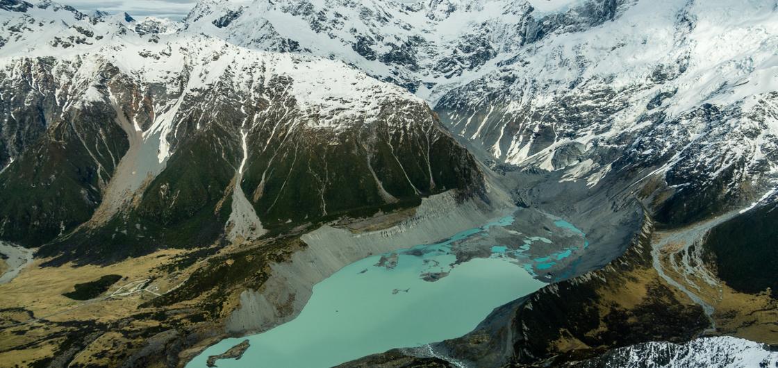 A glacier terminus lake with mountain peak beyond