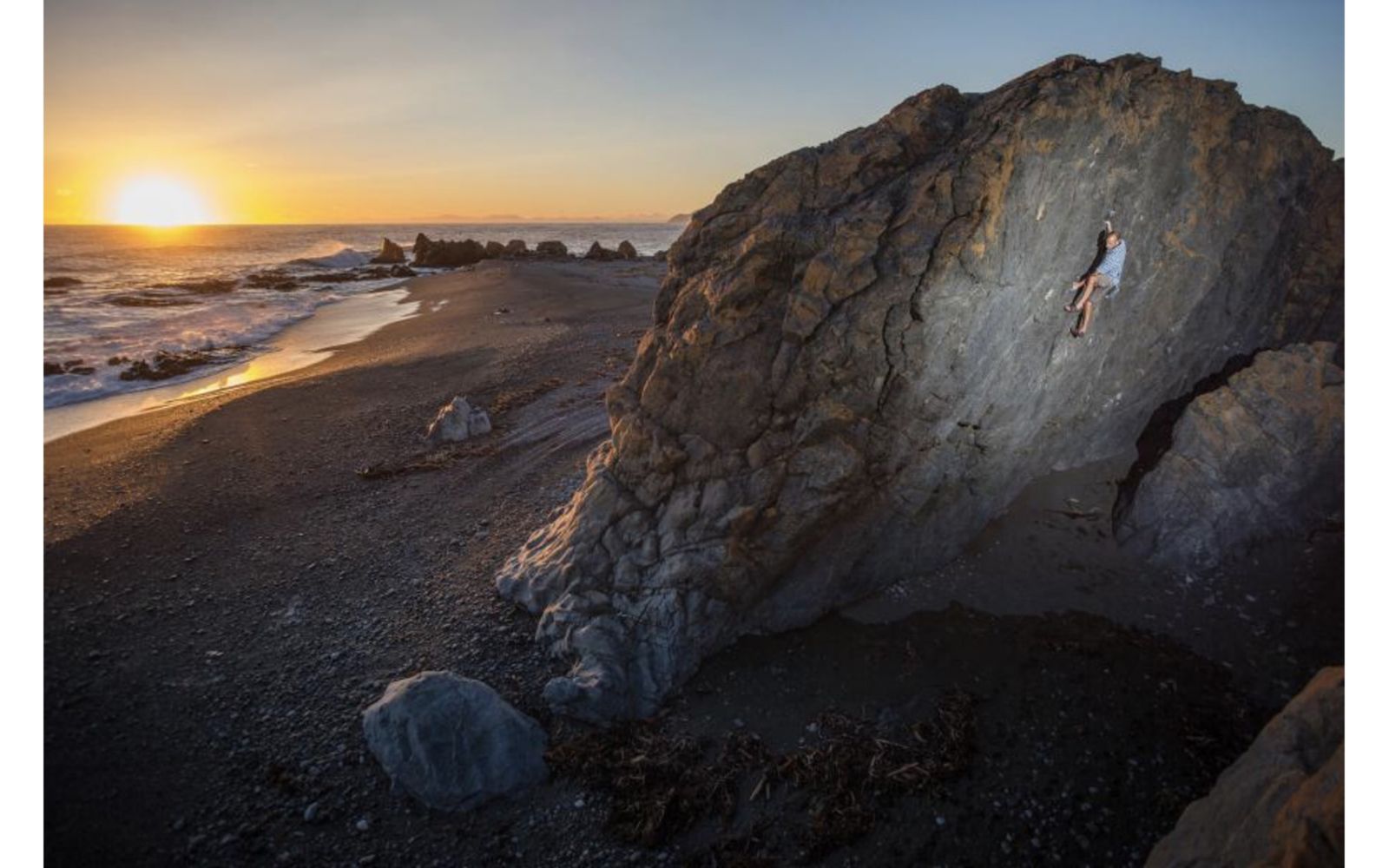 Climber on boulder at sunset.