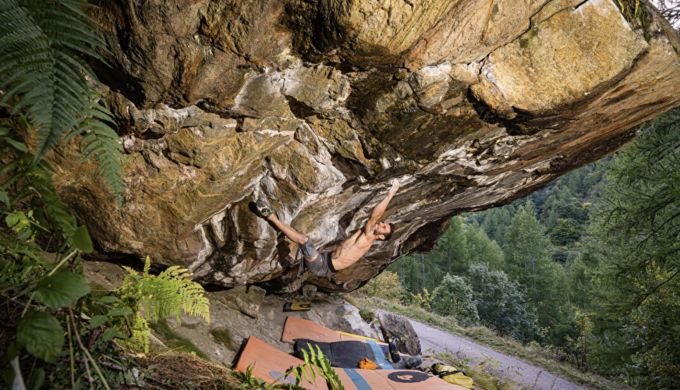 Climber on hard steep boulder problem