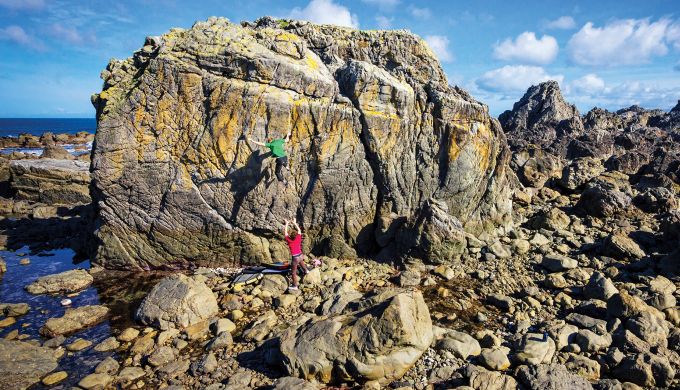 Boulderer falling from high on a seaside boulder