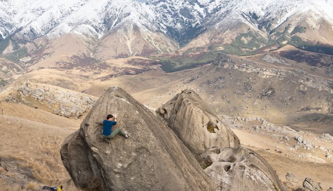 Female climber on boulder in alpine setting