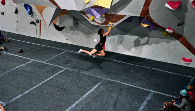 Female climber on competition boulder problem