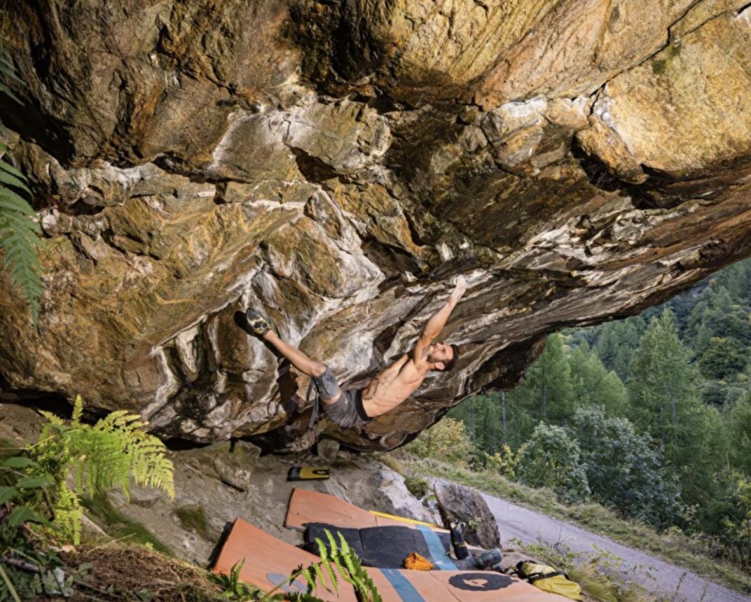 Climber on hard steep boulder problem