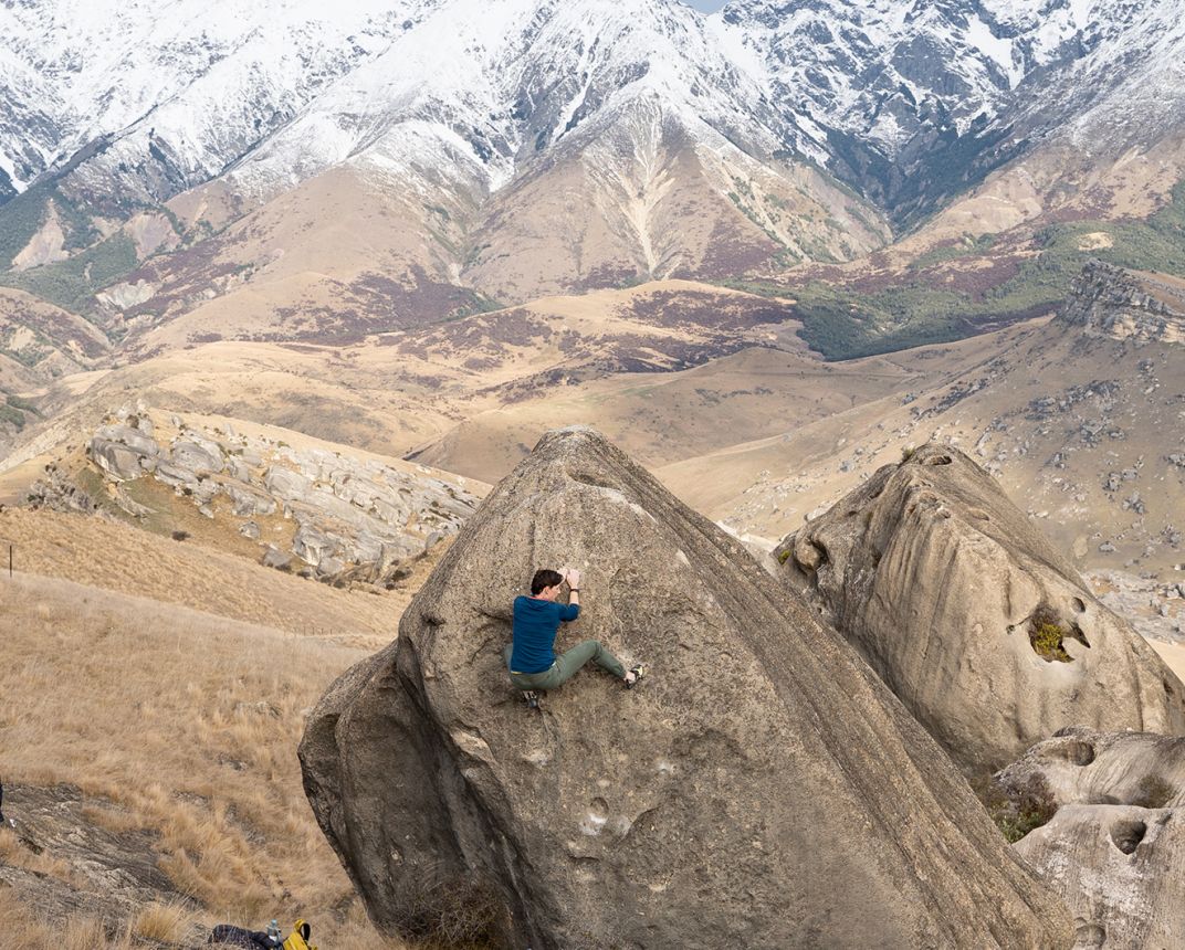 Female climber on boulder in alpine setting