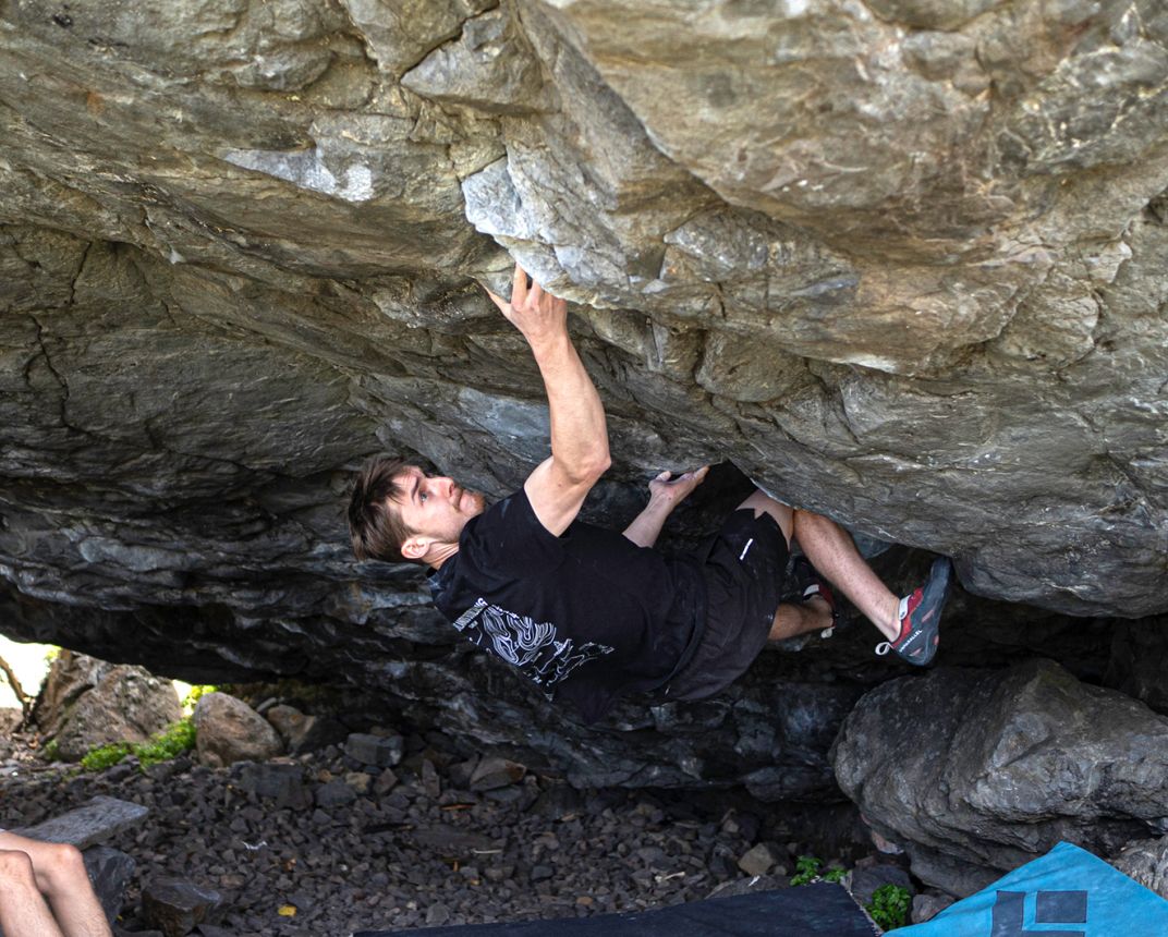 Boulderer on steep underside of boulder