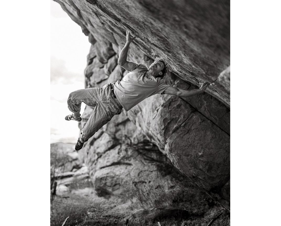 Climber on mega hard boulder with muscles in weird places