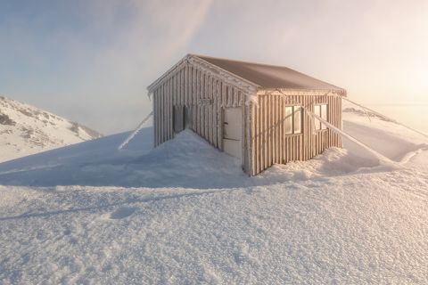 alpine hut covered in snow