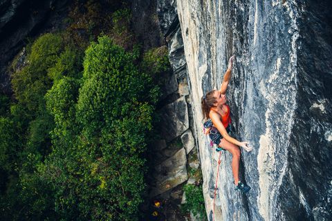 woman climbing on rock