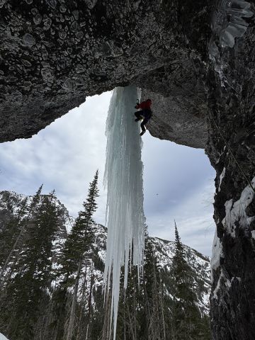 Ice climber on frozen waterfall