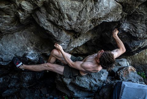 Boulderer on steep boulder