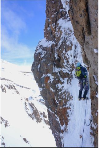 Ice climber on frozen waterfall