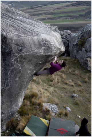 Female climber on steep boulder