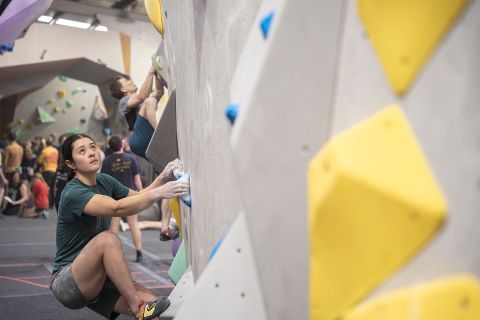 Competition climber attempts boulder problem