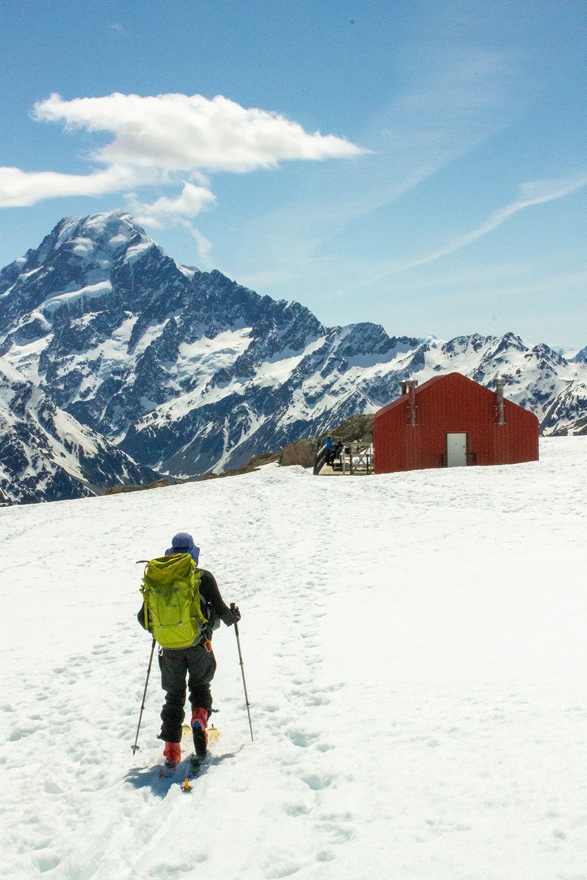 Skier approaching hut while ski-touring, Aoraki in the background.
