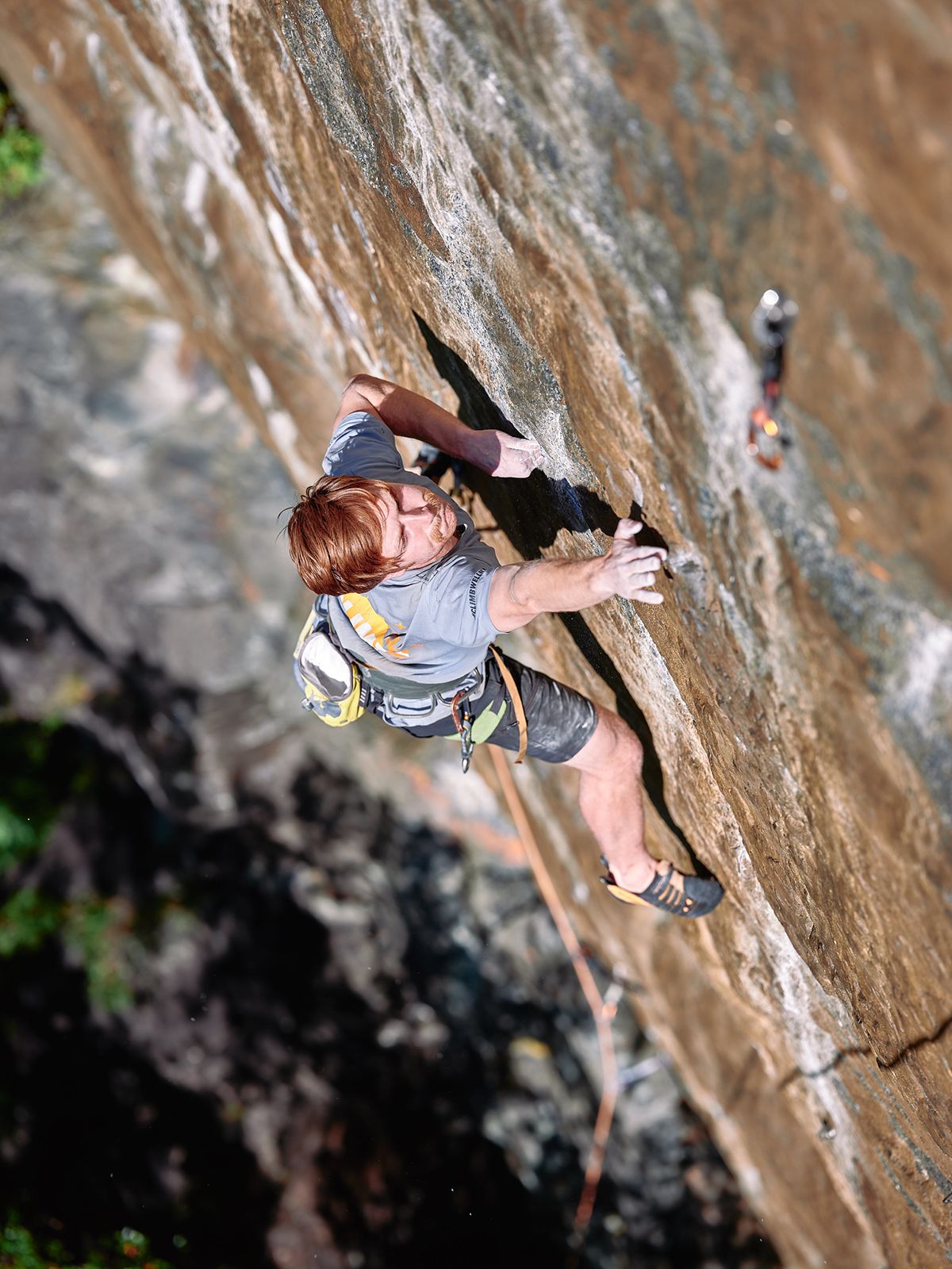 Ginger-headed rock climber on orange rock