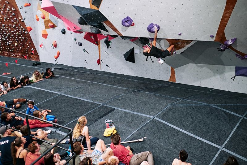 Female competitor on competition boulder problem