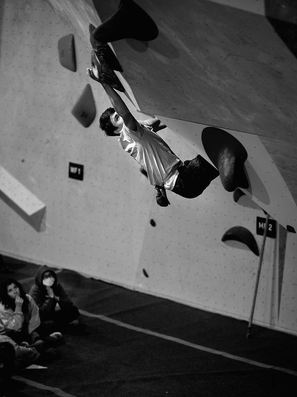 Male competitor on competition boulder problem