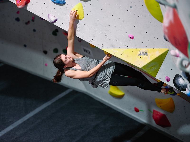 Female competitor on competition boulder problem