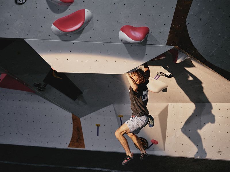 Male competitor on competition boulder problem