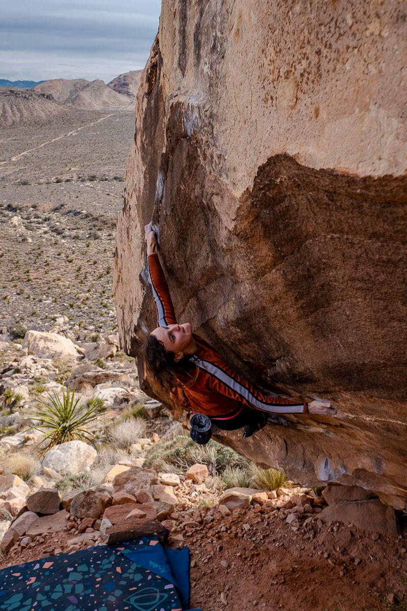 Boulderer hugging sandstone boulder