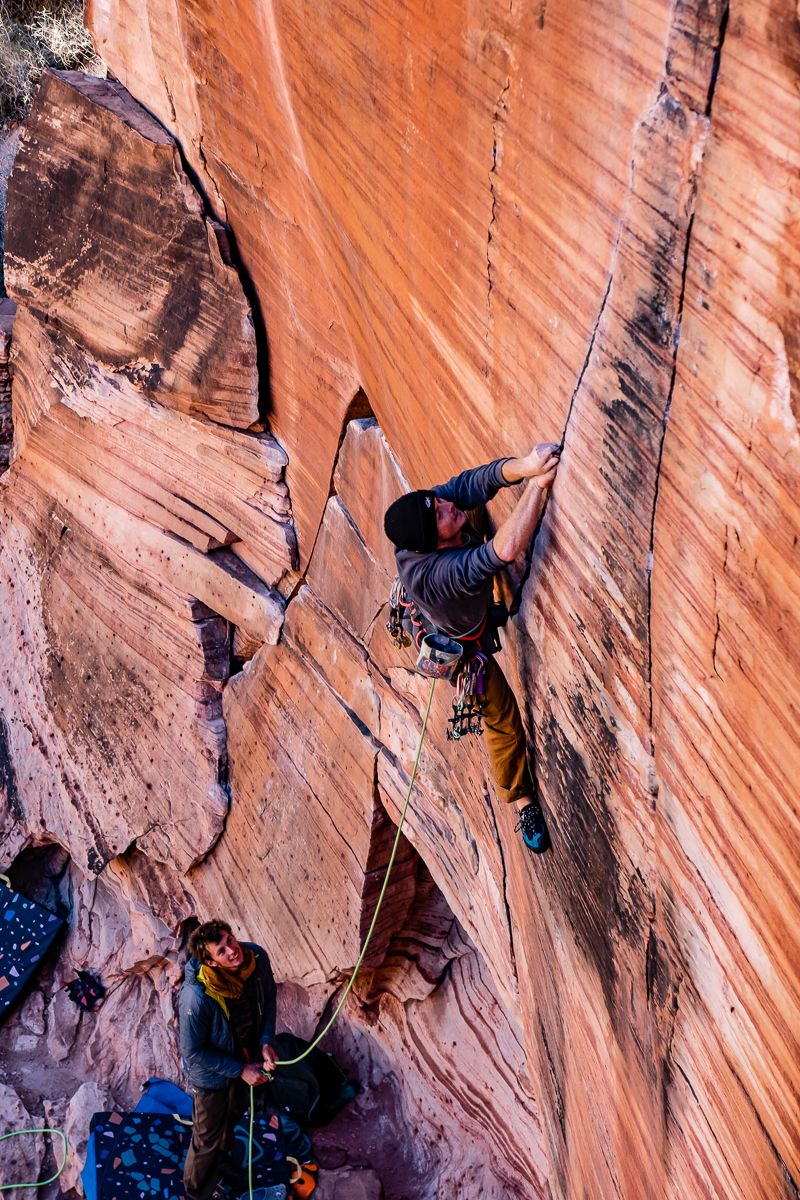 Trad climber on colourful wall