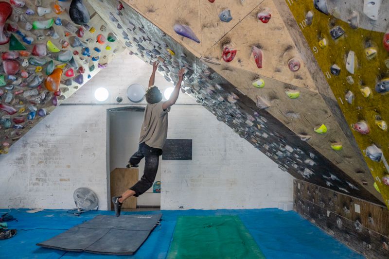 Boulderer footless on steep wooden training board