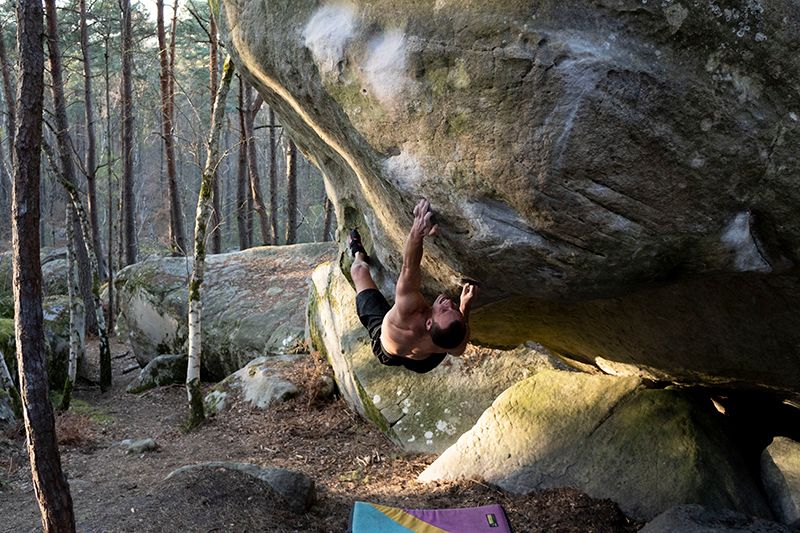 Climber tries hard on steep boulder