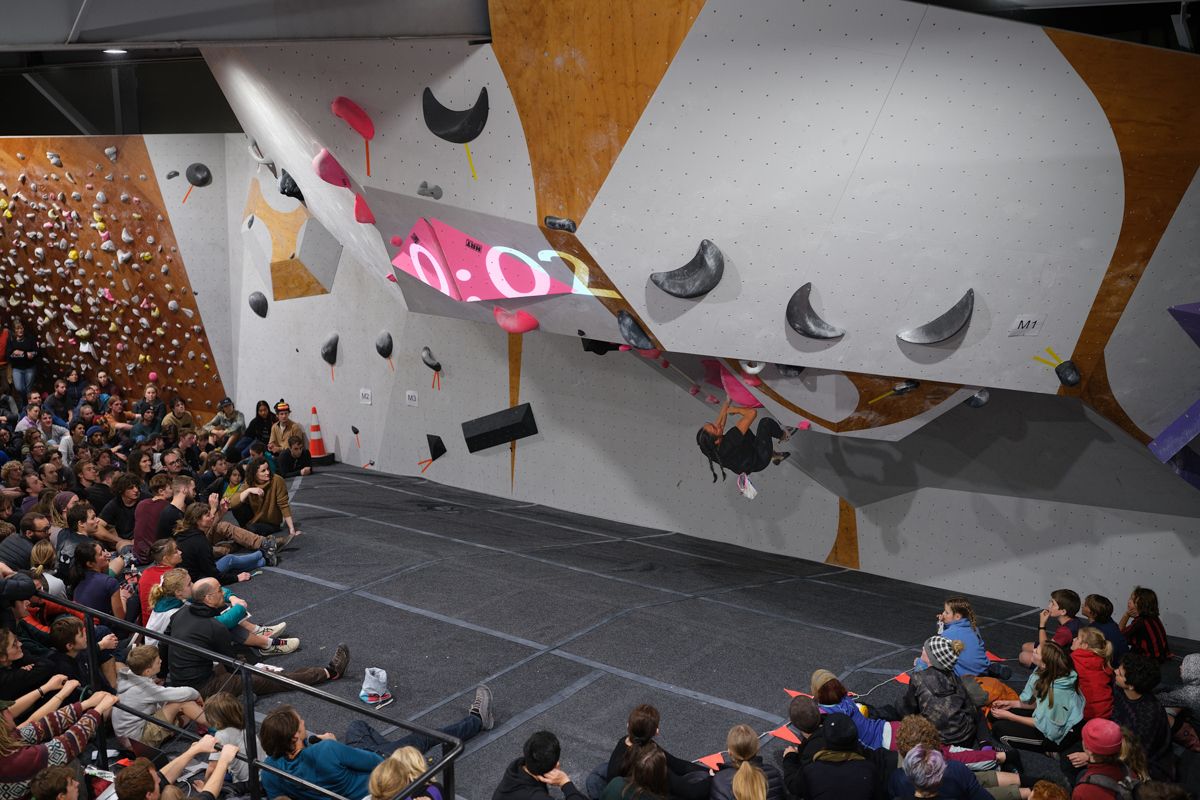 Female competitor on competition boulder problem