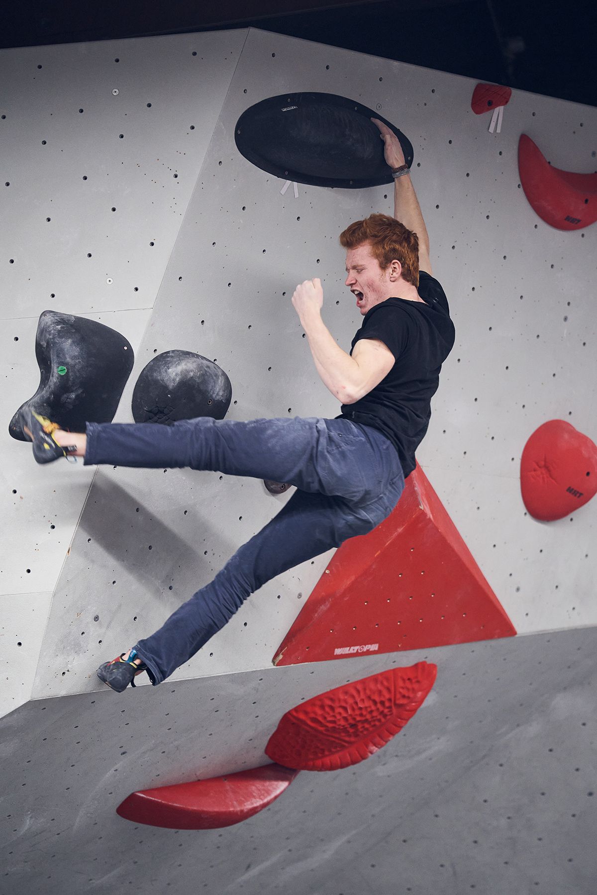 Male bouldering competitor celebrates victory with obligatory fist pump