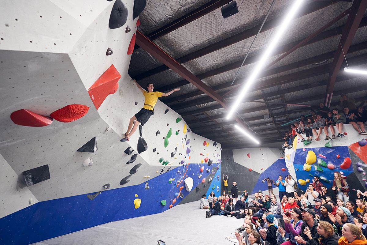 Male bouldering competitor celebrates top