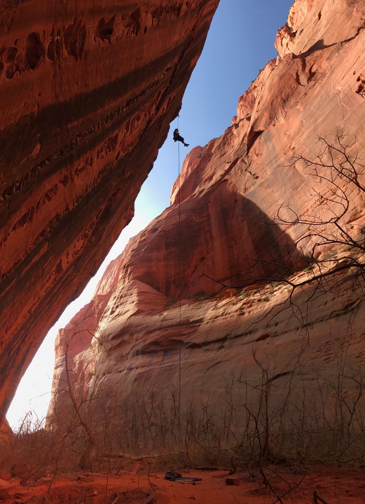A climber abseils in a canyon of desert sandstone