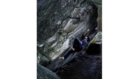 Barefoot climber on steep boulder