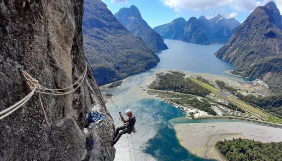 Climber on big wall above fiords.