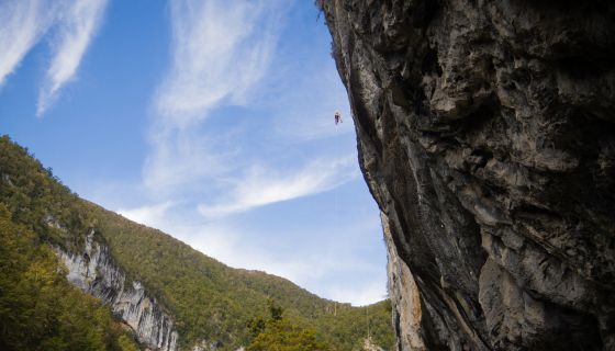 Climber abseils down huge steep wall 